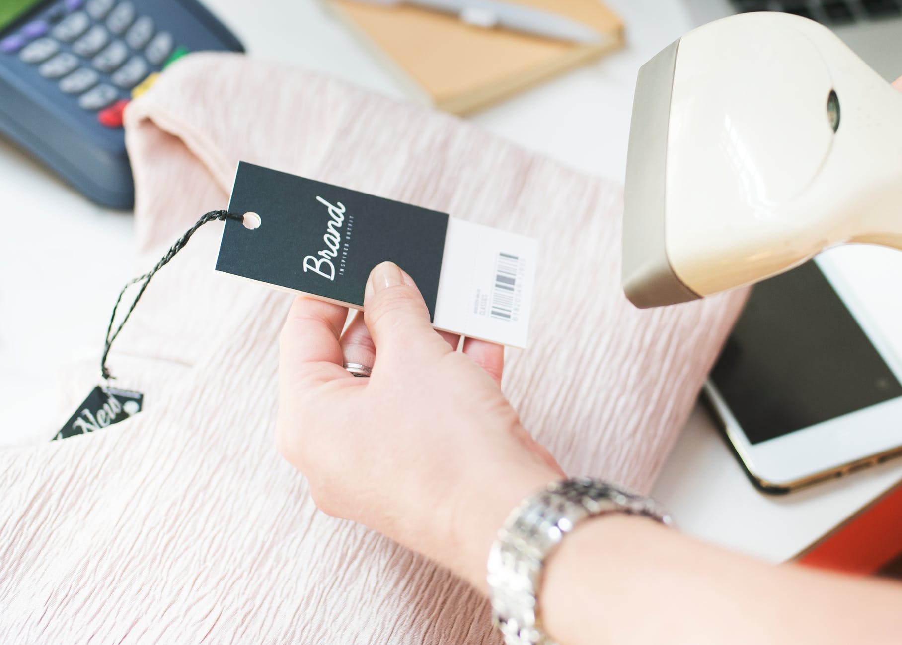 A human hand holding the scanning machine and  scanning the barcode